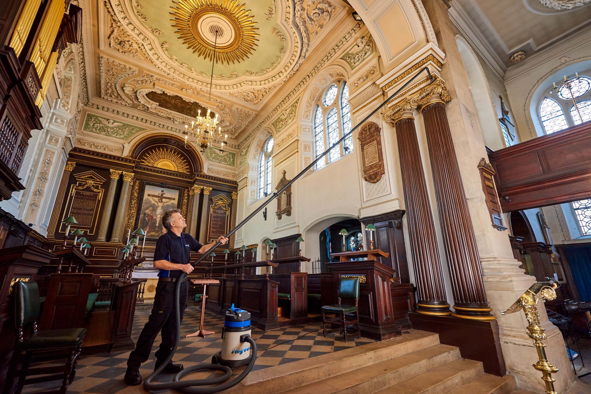 A living room with a couch , table , chairs and paintings on the wall.
