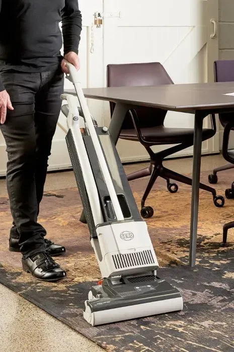 Upright vacuum cleaner, white and black, standing upright.