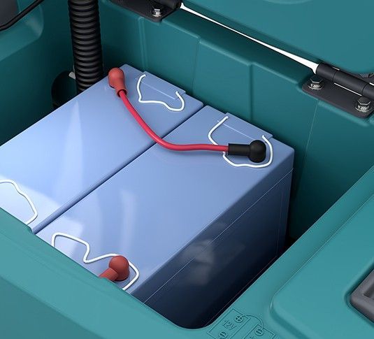 Teal and gray automatic floor scrubber with circular scrubbing pads, wheels, and a handle.