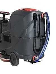 Gray and red ride-on floor scrubber with steering wheel, for cleaning floors.
