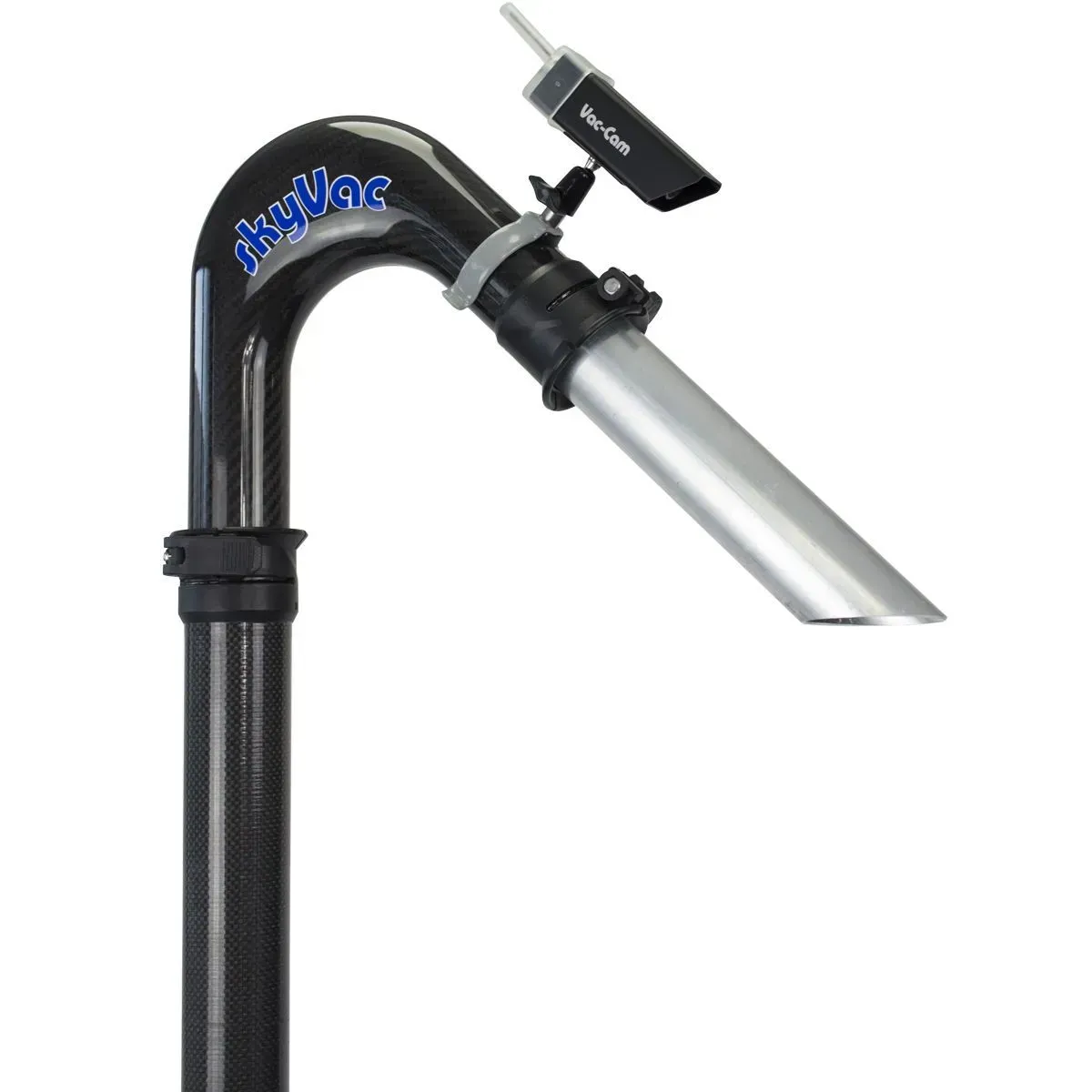 A gloved hand holds a monitor showing a camera view of a yard with equipment; lush green grass.