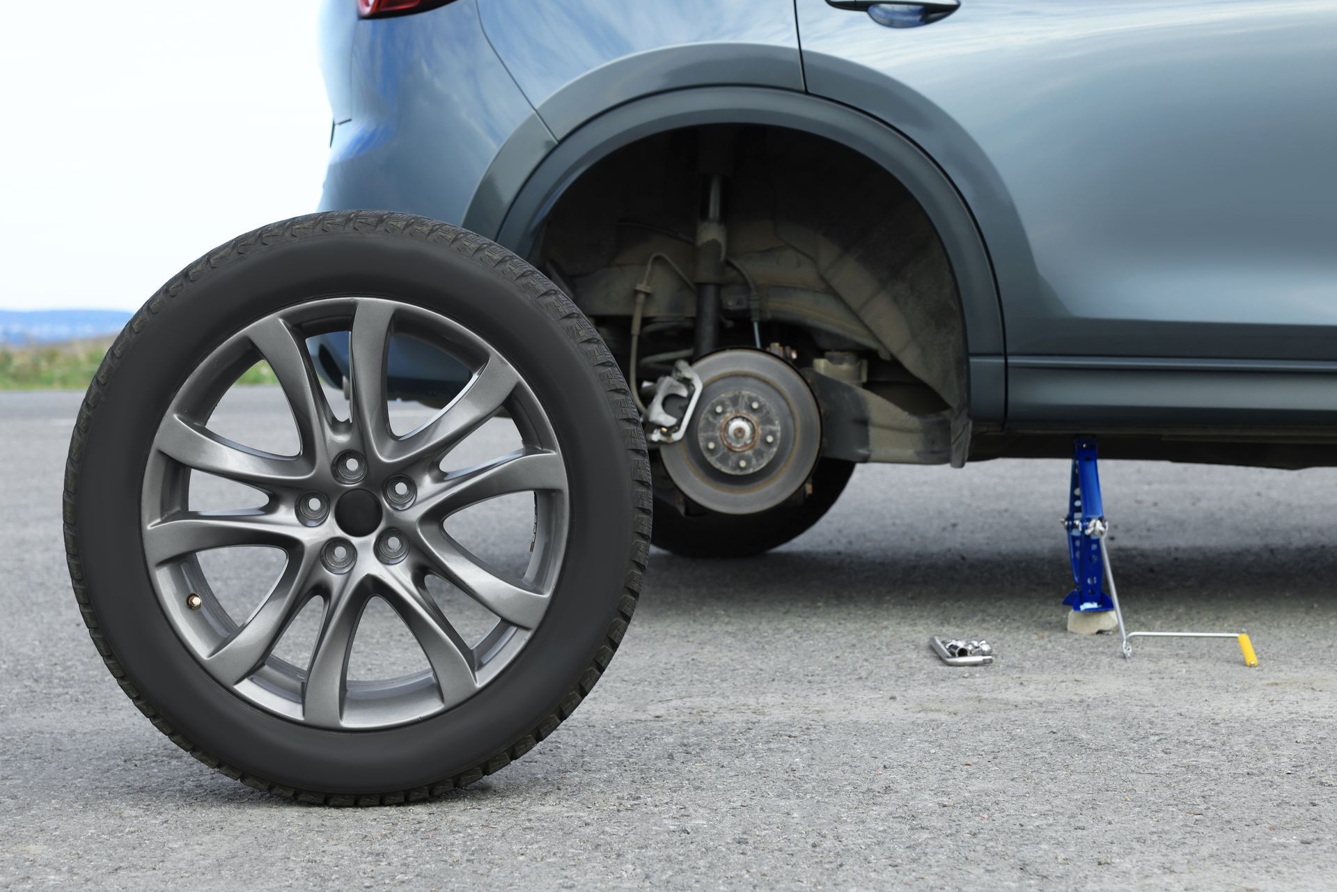 A car with a flat tire is sitting on a jack.