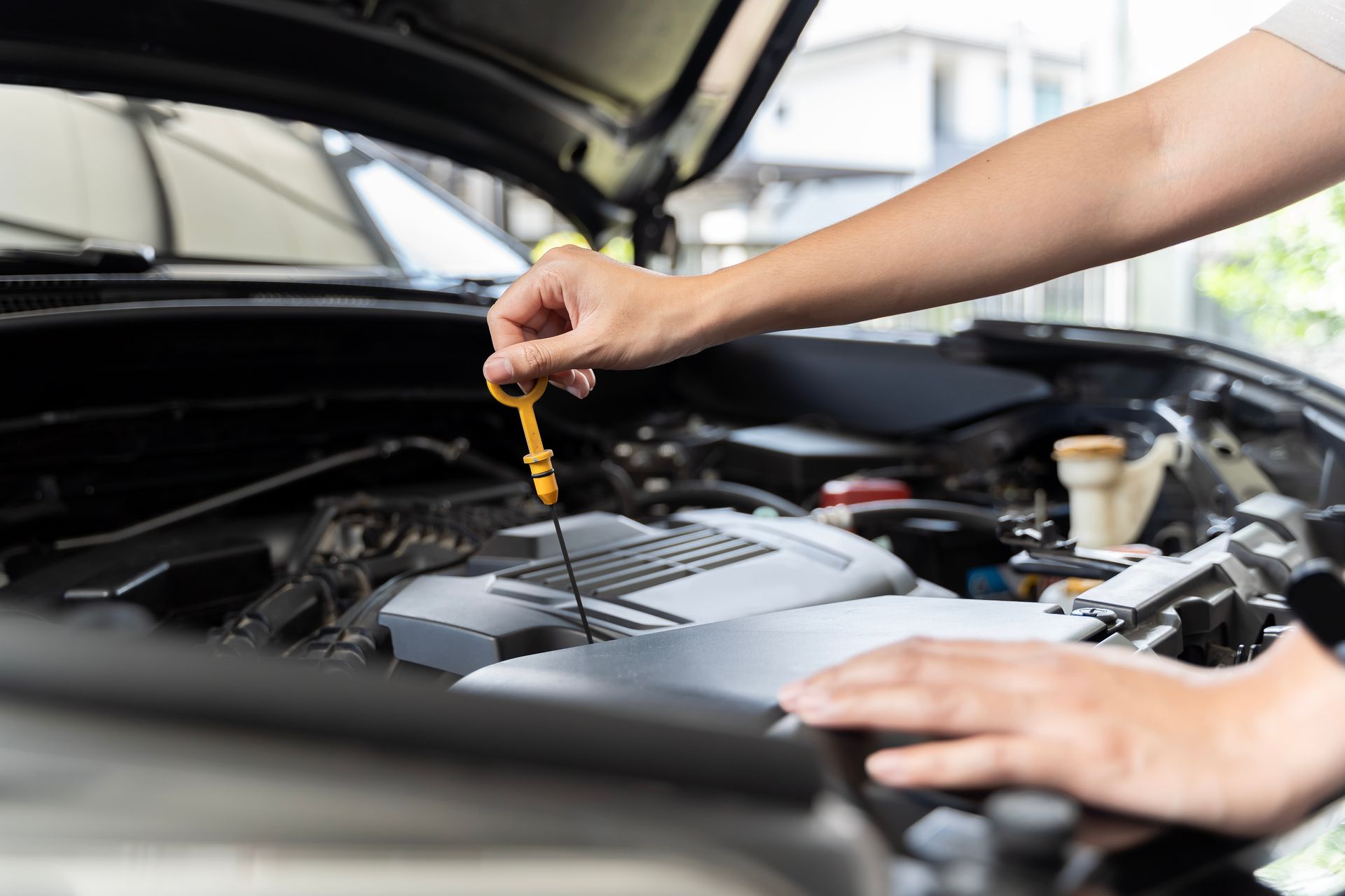 A person is checking the oil level of a car.