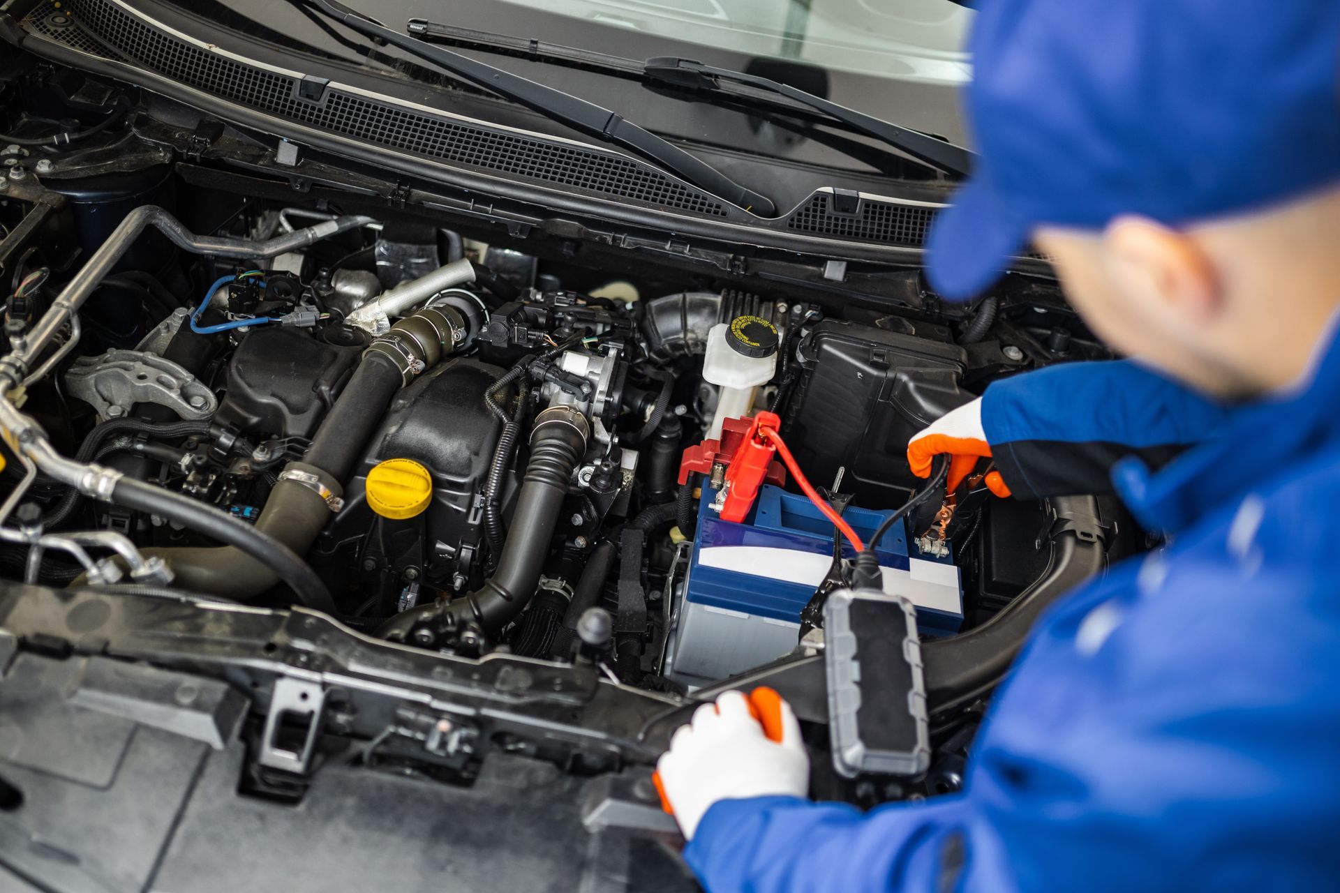 A mechanic is working on the engine of a car.