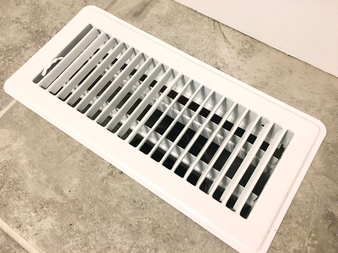 White Floor Air Vent Grille Set Into a Gray Carpeted Floor — Alpine Refrigeration & Air Conditioning Pty Ltd in Kiama, NSW