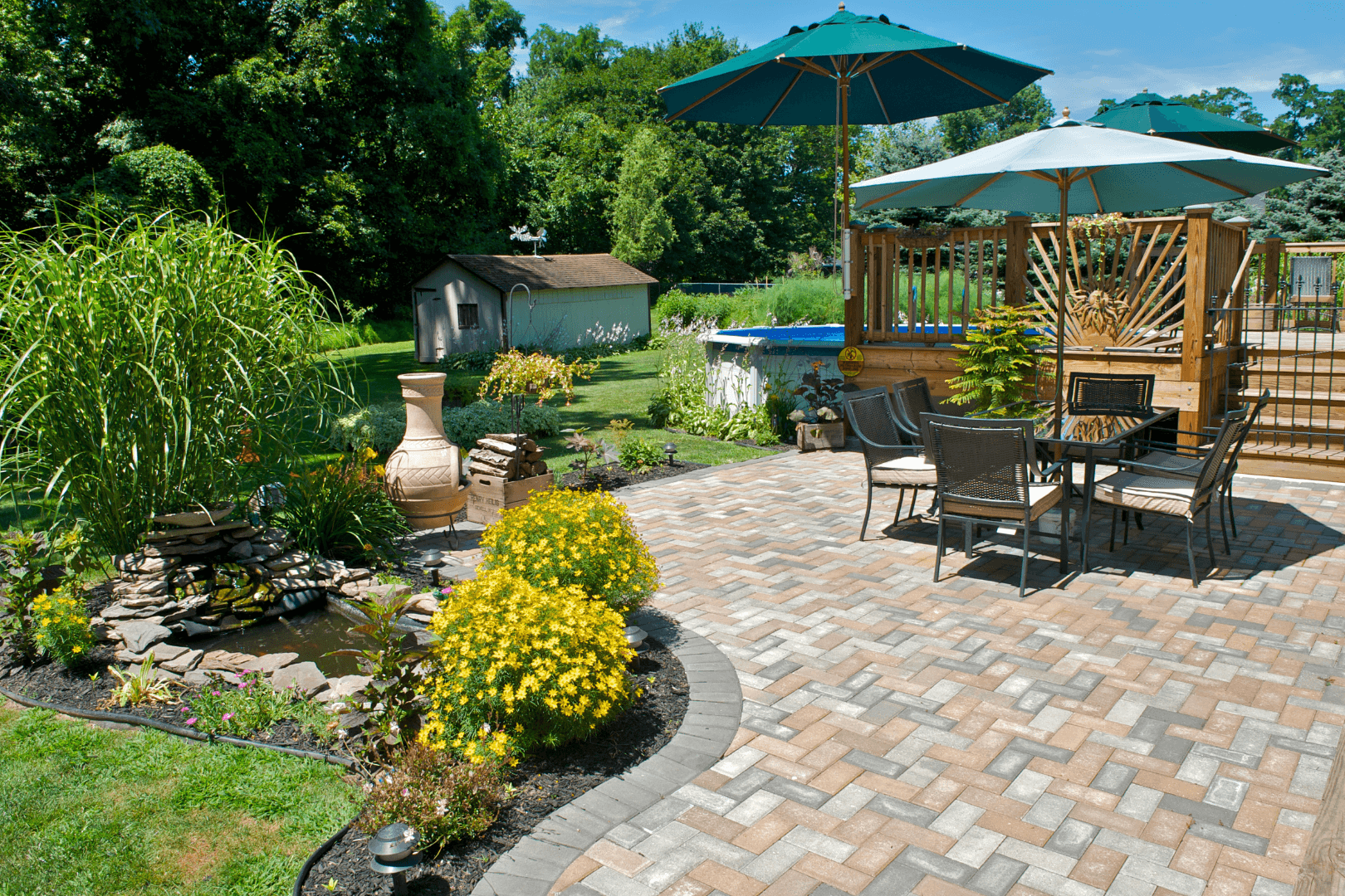 Workers leveling wet concrete with a bull float to create a sidewalk. One wears a neon vest and jeans.