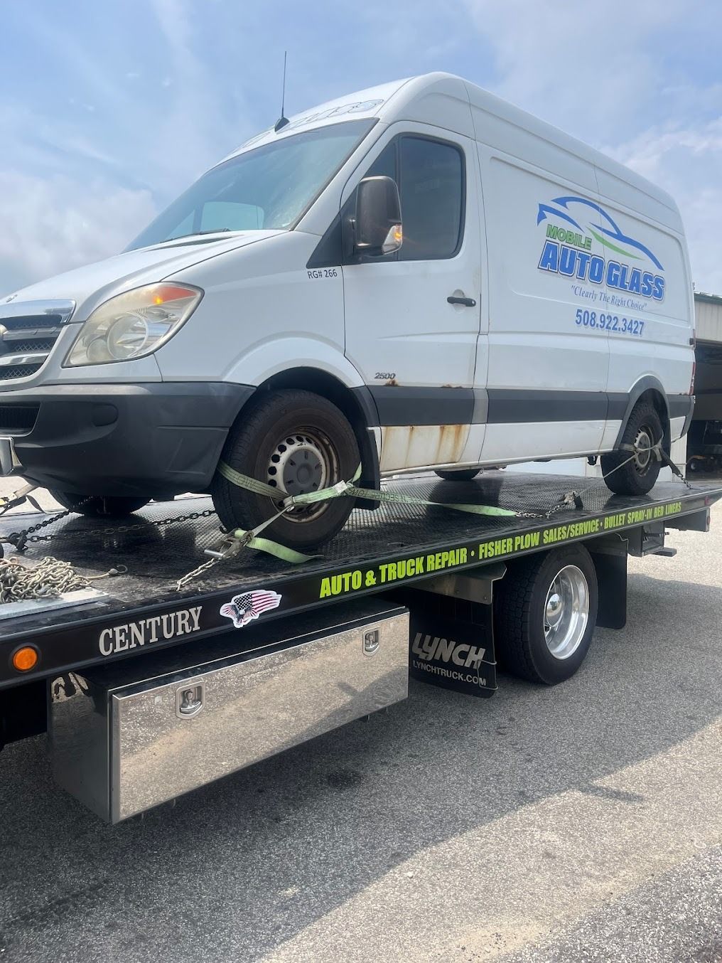 A white van is sitting on top of a tow truck.
