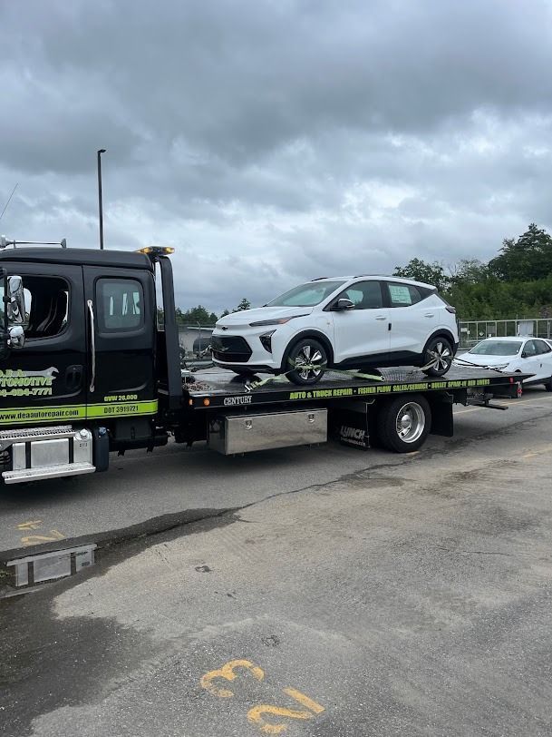 A white car is being towed by a tow truck.
