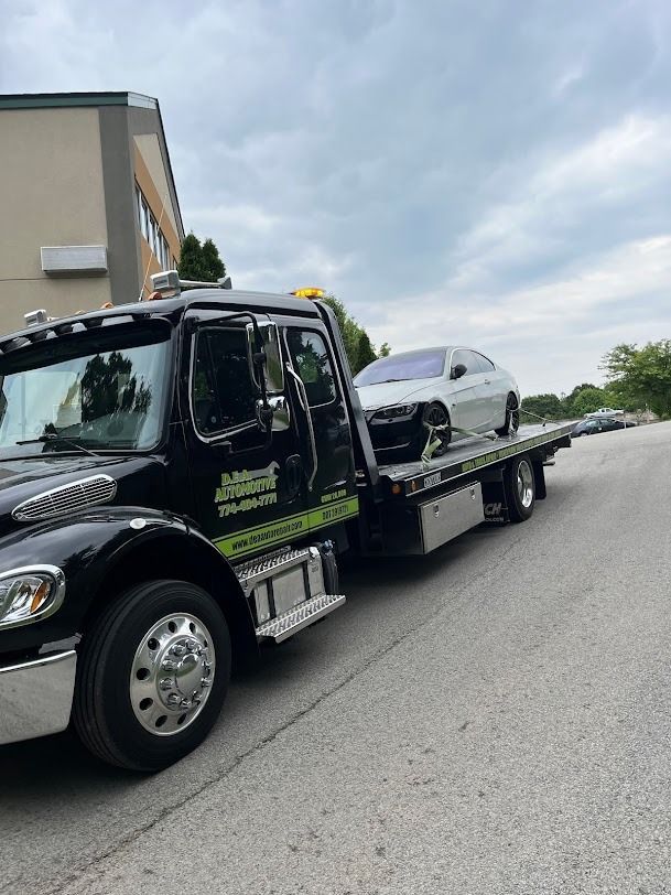 A tow truck is carrying a car on the back of it.