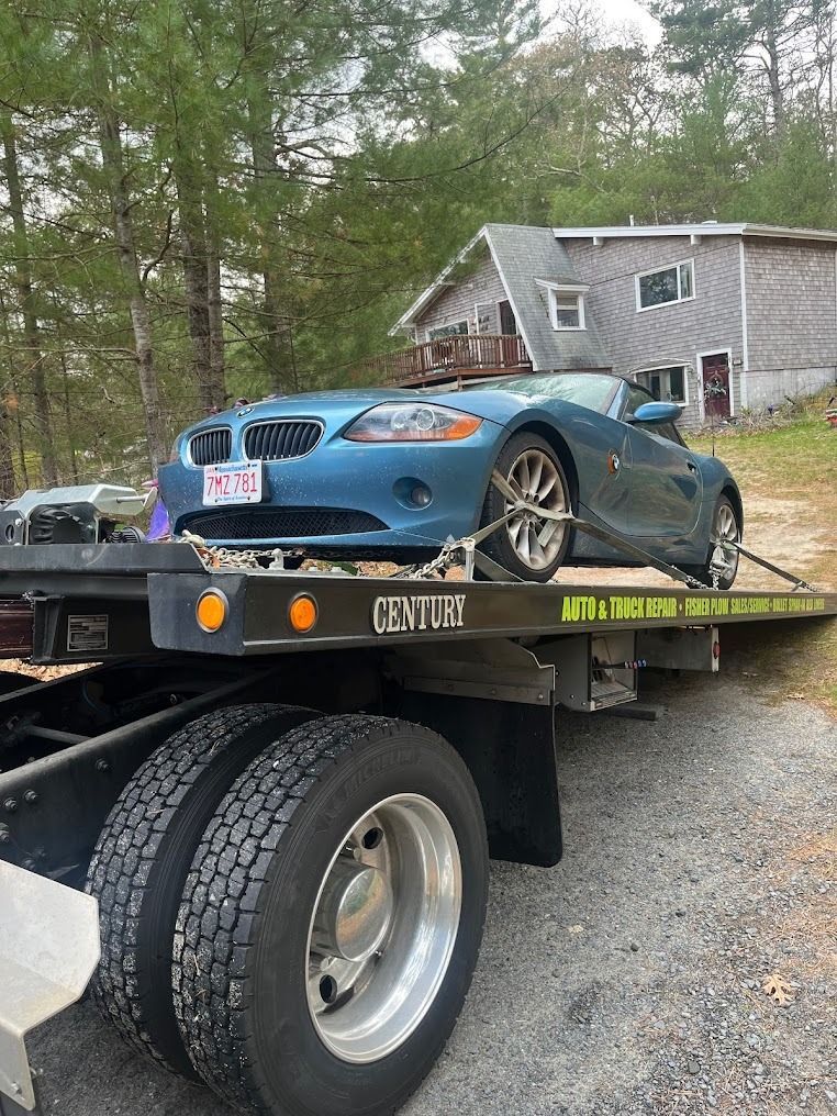 A blue car is sitting on top of a tow truck.