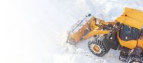 A yellow snow plow is clearing snow from a road.