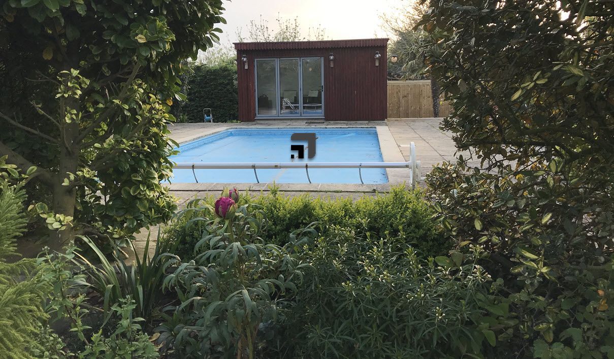a swimming pool with a wooden garden building in the background