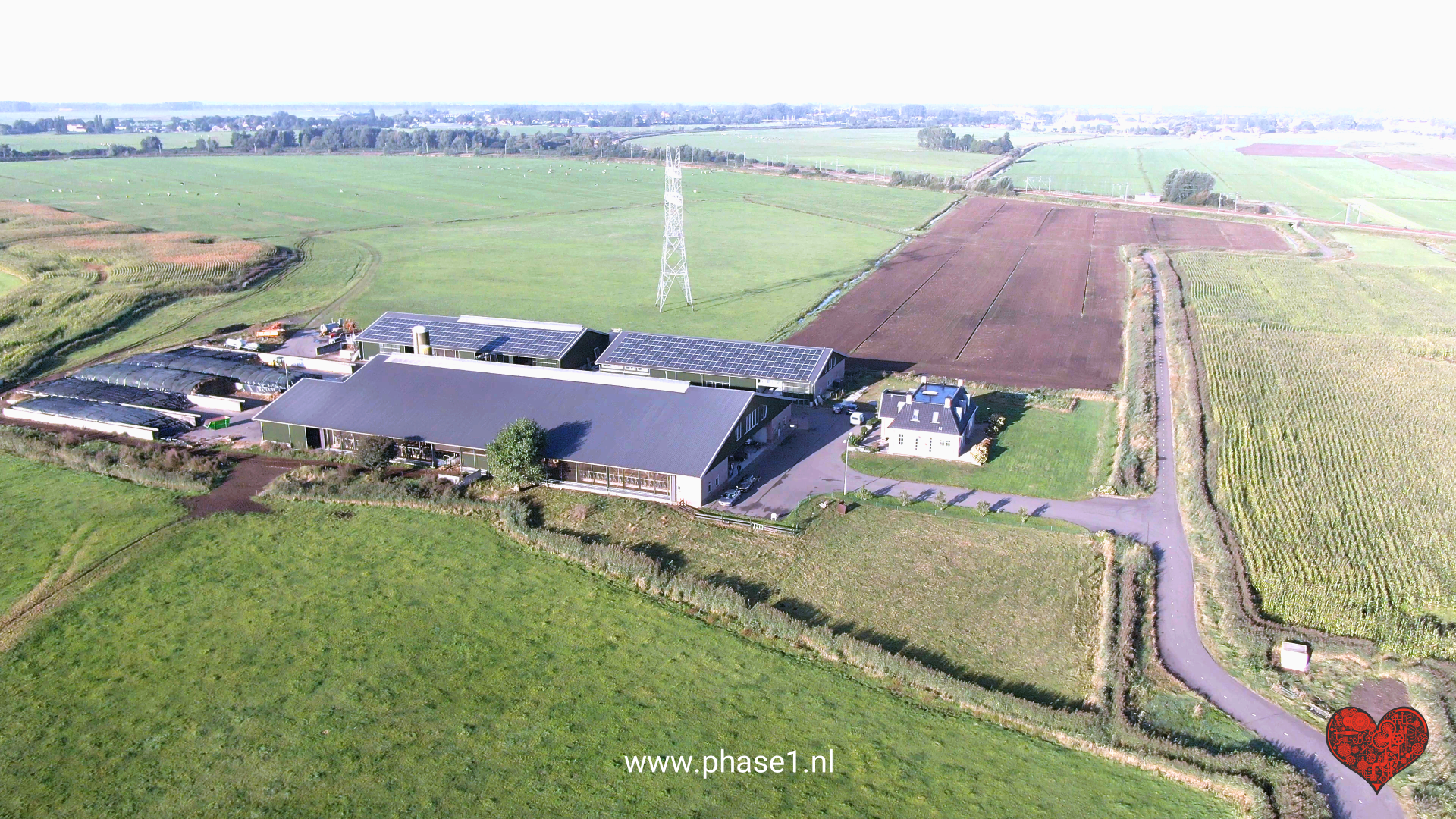 Een luchtfoto van een boerderij met een hart op de voorgrond