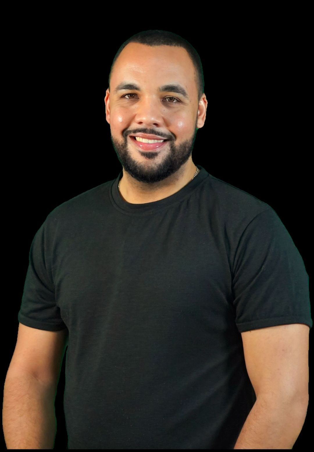 A man with a beard is wearing a black shirt and smiling.