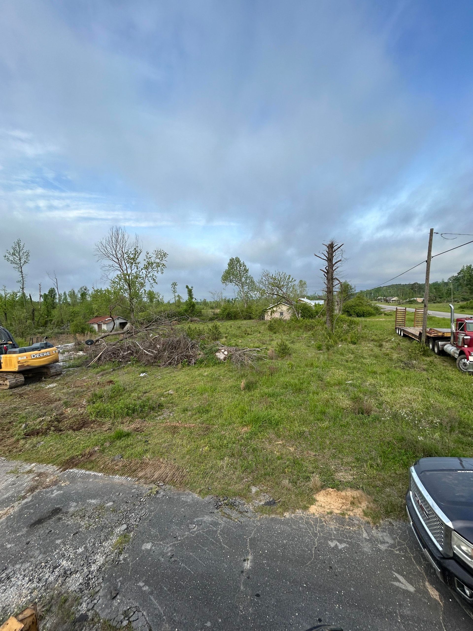 A truck is parked on the side of the road in a field.