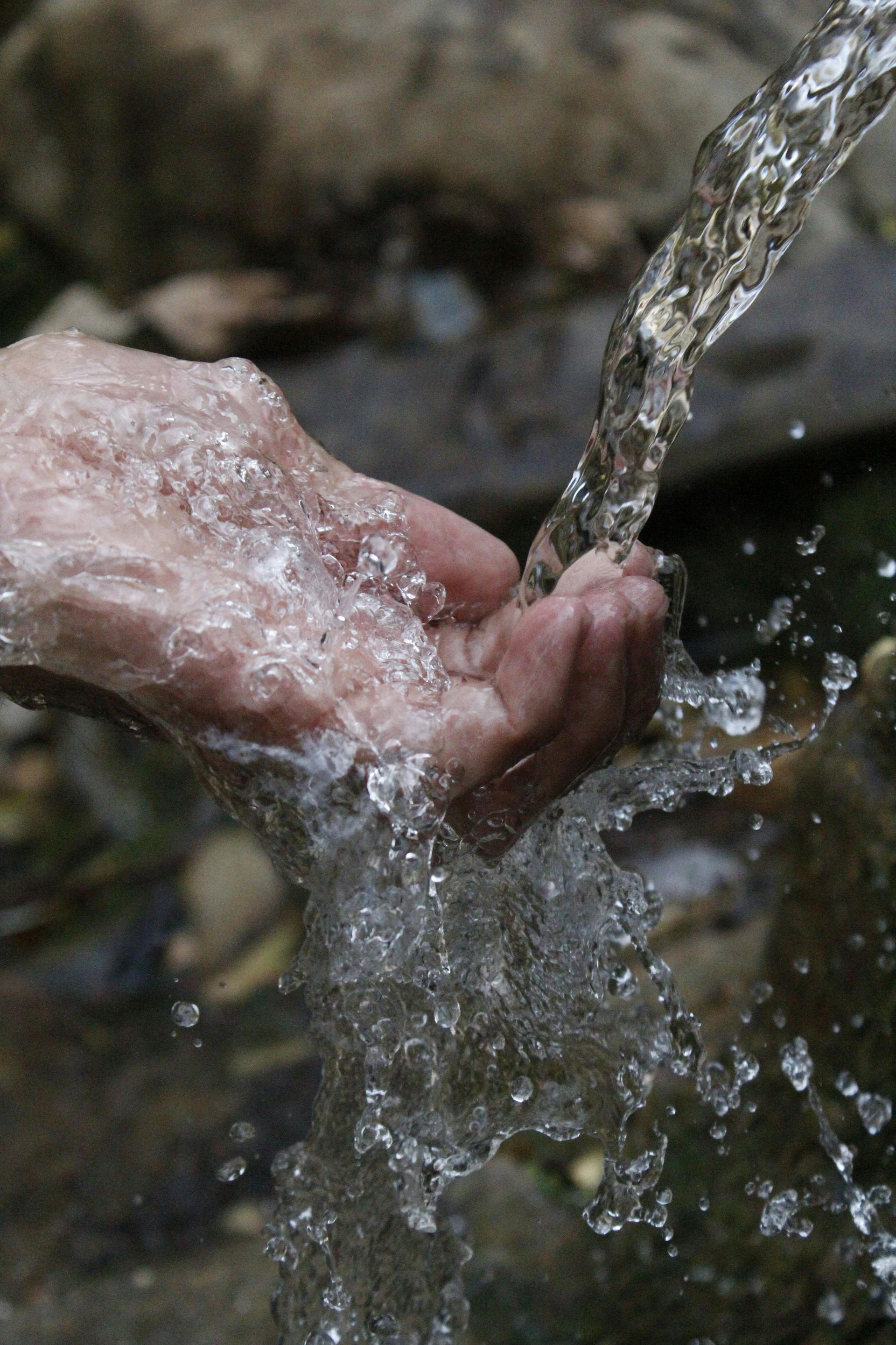 A drop of water is splashing on a blue surface.