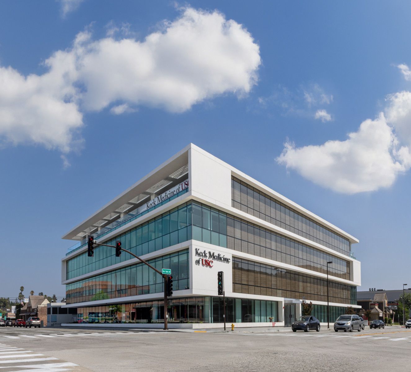 A strip mall with T-Mobile store signs and cars parked out front on a sunny day.