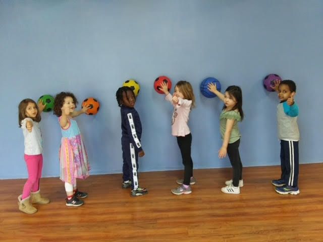 children with balls against wall