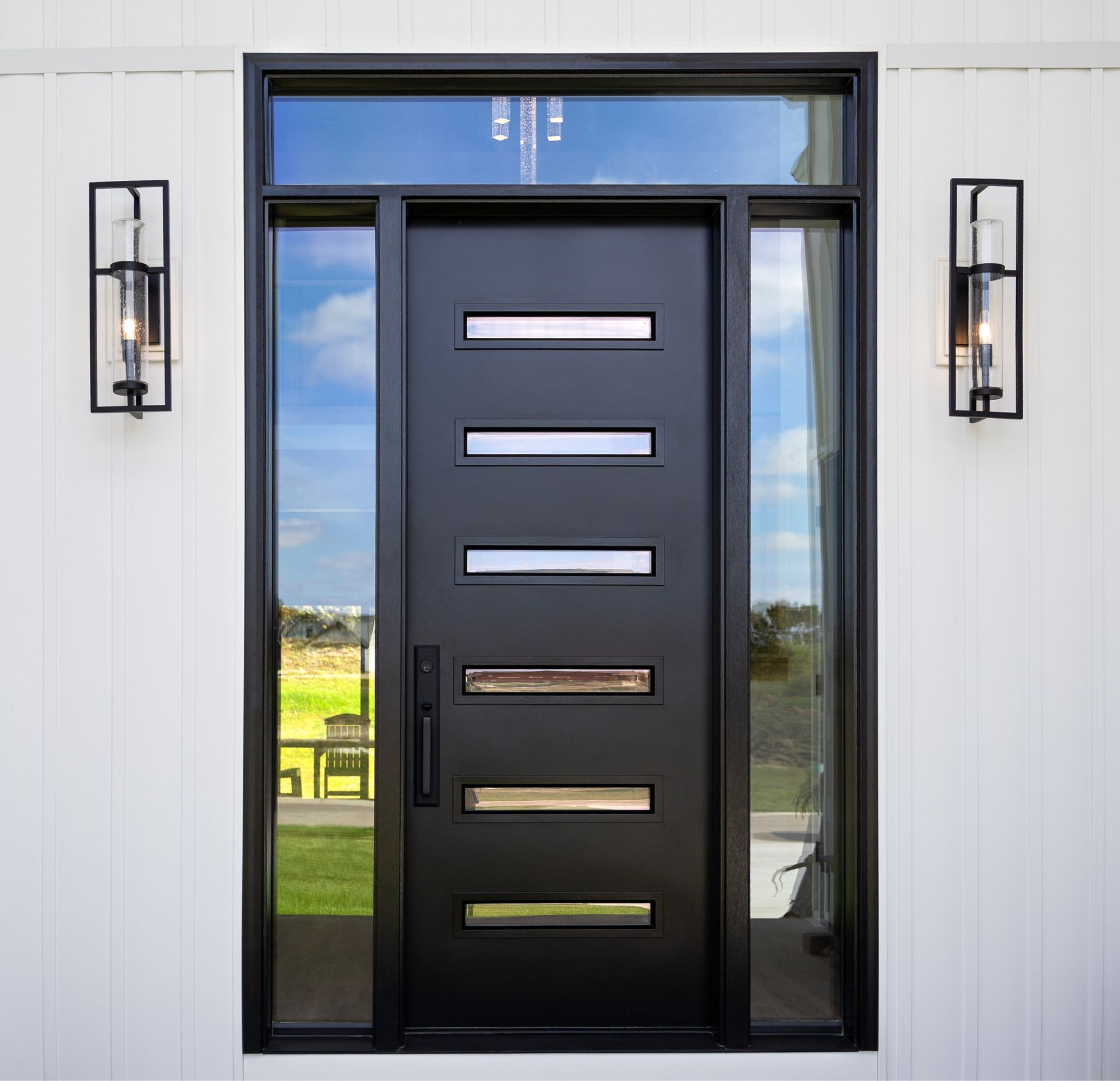 Black double entry doors with glass panels framed by porch decor and white rocking chairs.