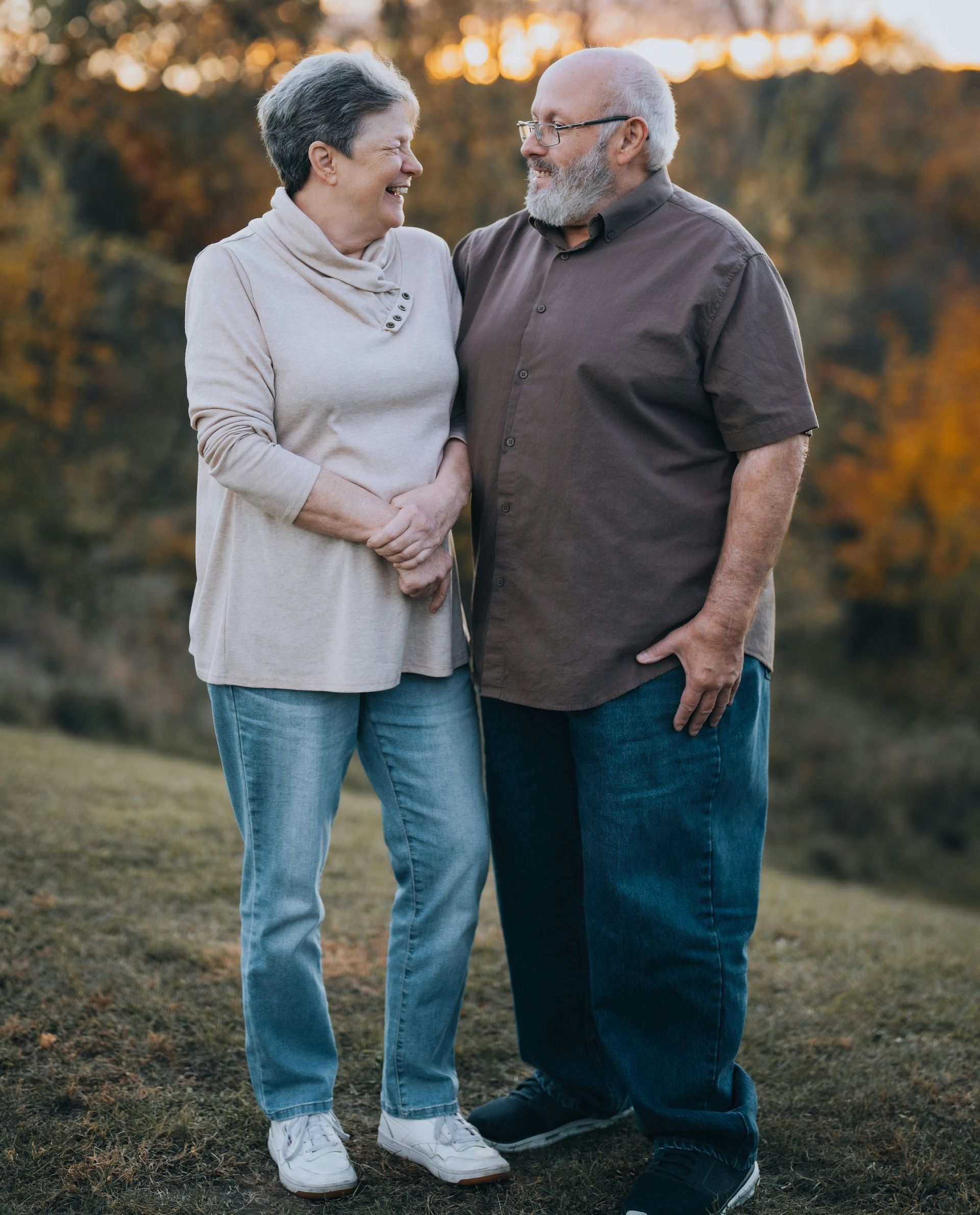 A man and a woman are standing next to each other on a hill.