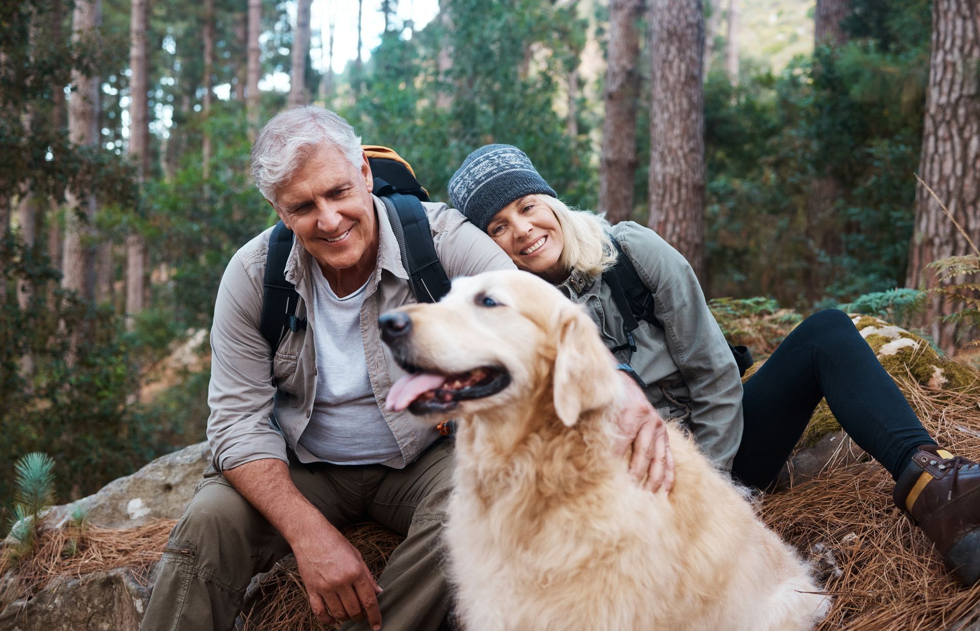 A family is sitting next to a dog wearing a cowboy hat.