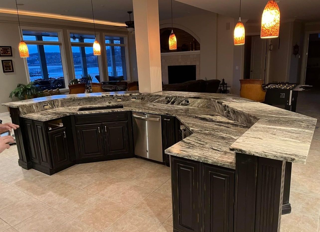 A kitchen with a large island and granite counter tops.
