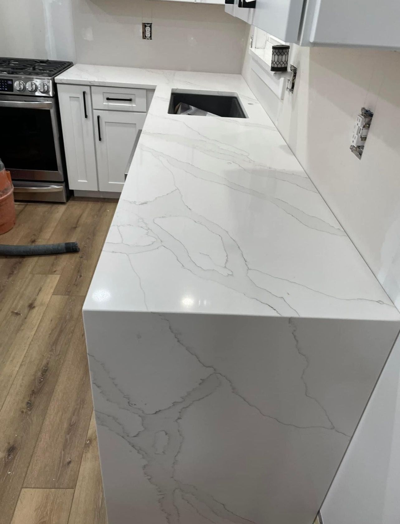 A kitchen with a large white counter top and a sink.