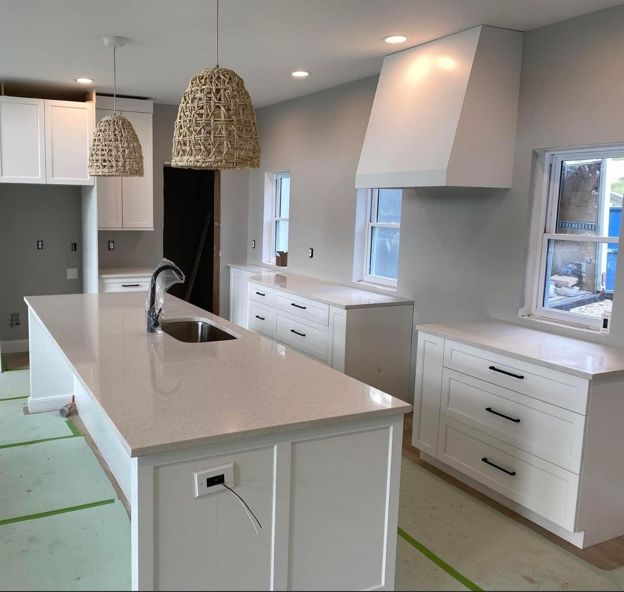 A kitchen with white cabinets and a large island