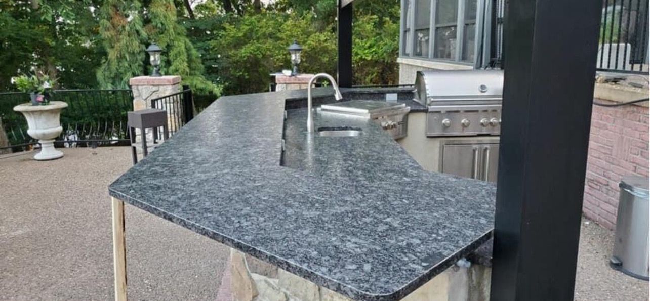 A kitchen with a black granite counter top and a sink.