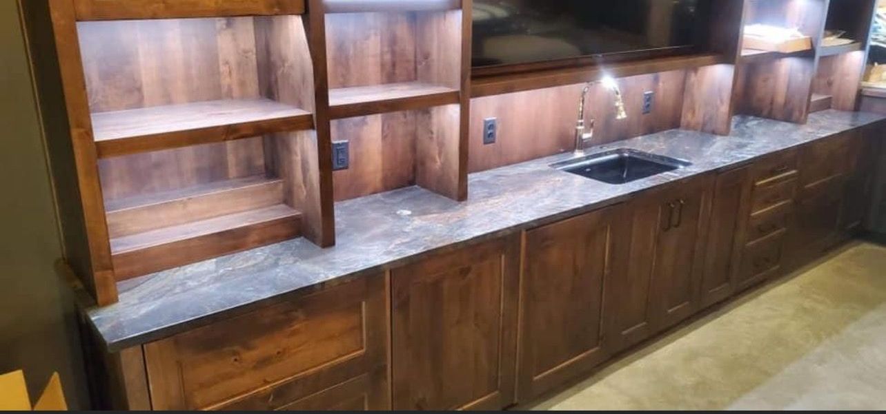 A kitchen with wooden cabinets , granite counter tops , and a sink.