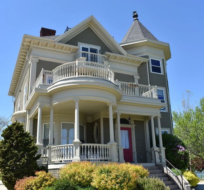 A large house with a large porch and a red door