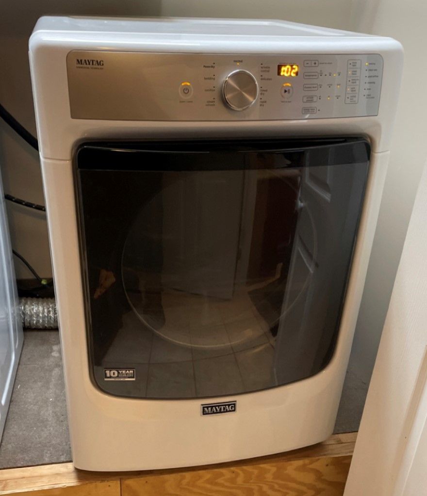 White Maytag dryer with a glass door and control panel.
