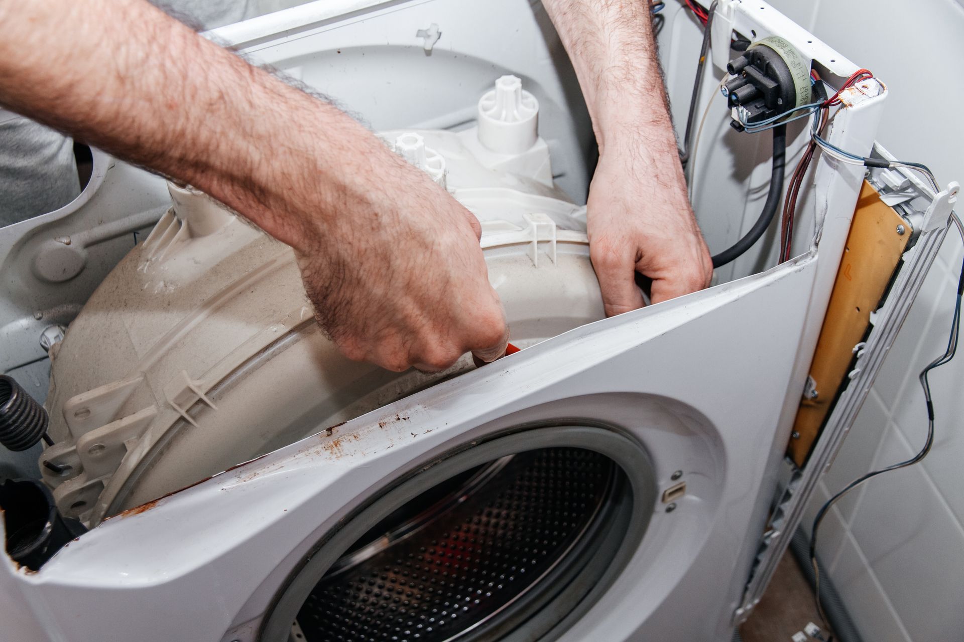 Handyman repairing a washing machine. Handyman repairing a washing machine.