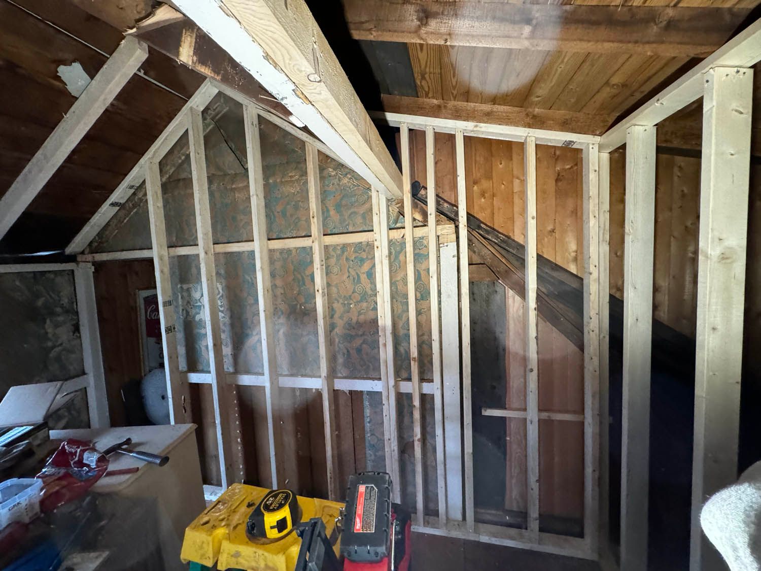 A room with wooden walls and a toolbox on the floor.