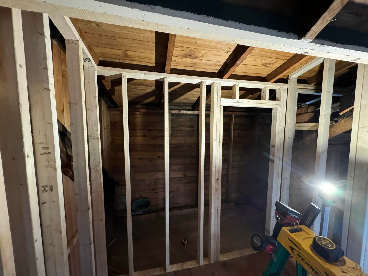 A room is being built with wooden beams and a ladder.