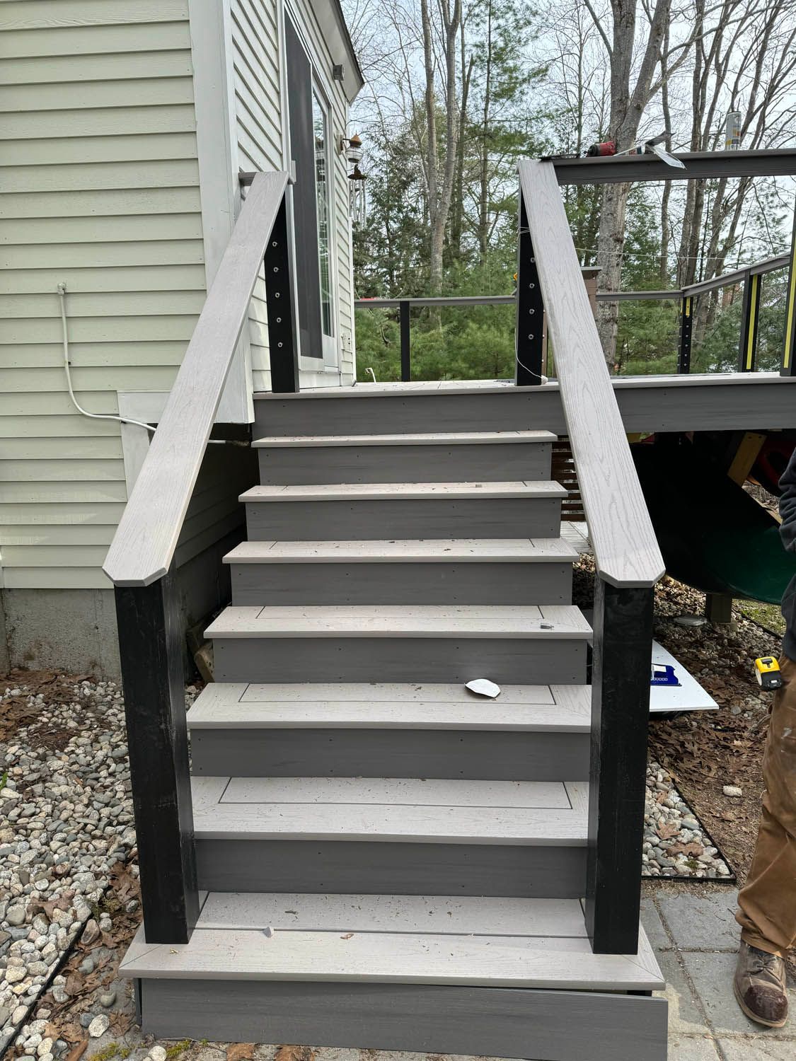 A set of stairs leading up to a deck next to a house.