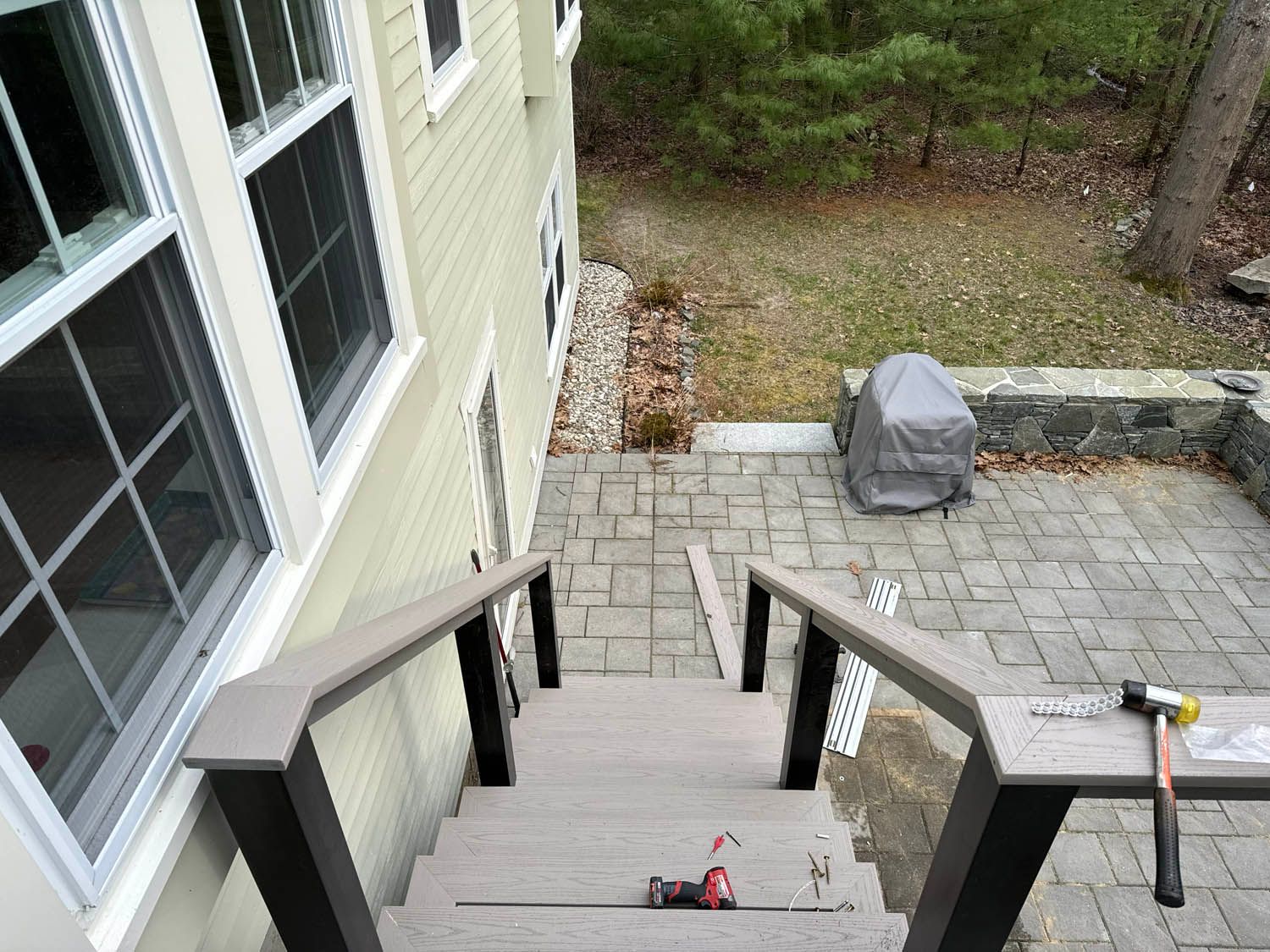 A set of stairs leading up to a patio in front of a house.
