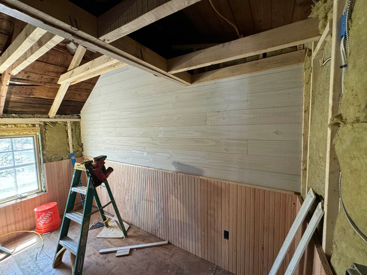 A room with wood paneling and a ladder in it.