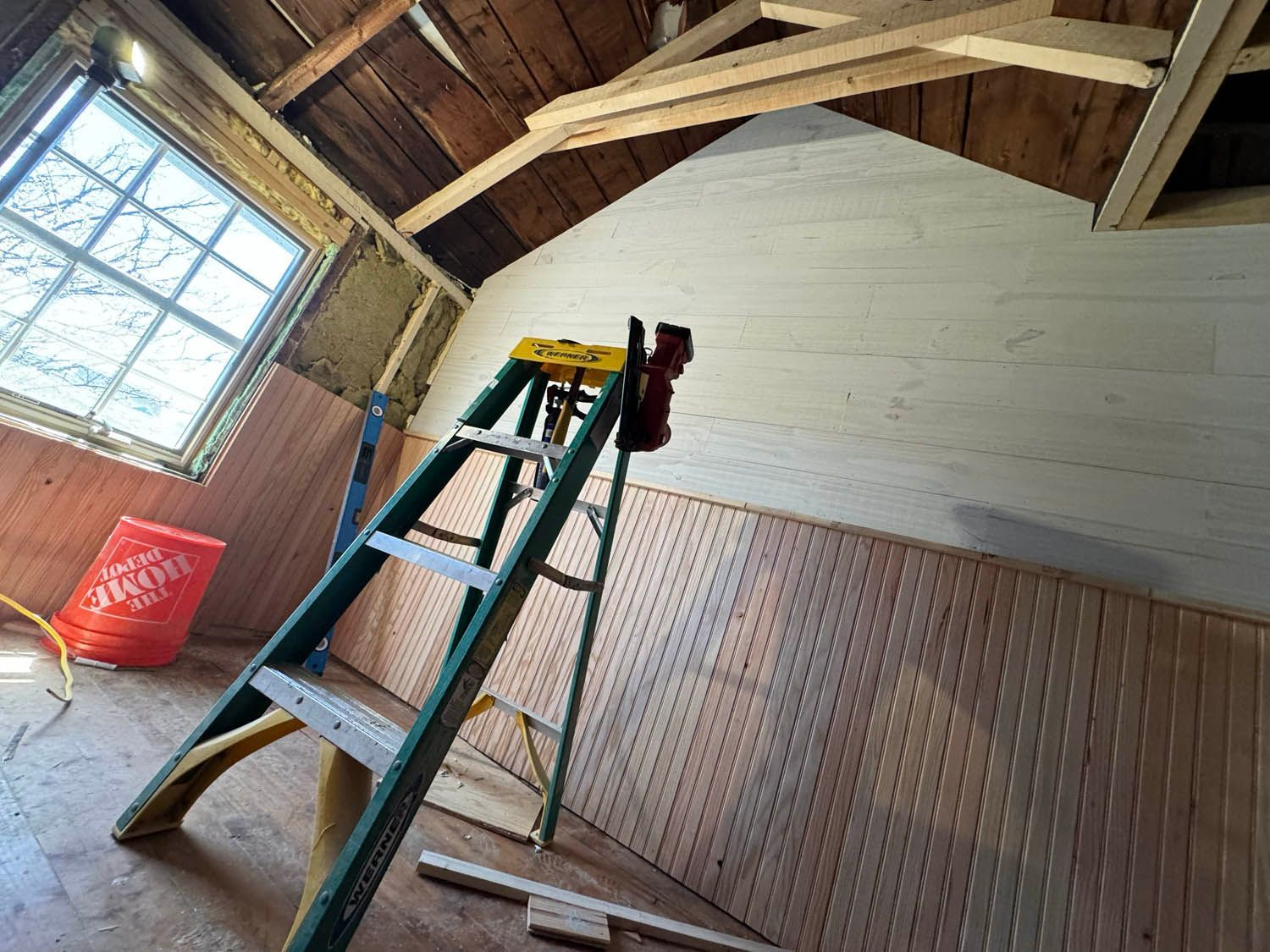 A ladder is leaning against a wall in a room under construction.