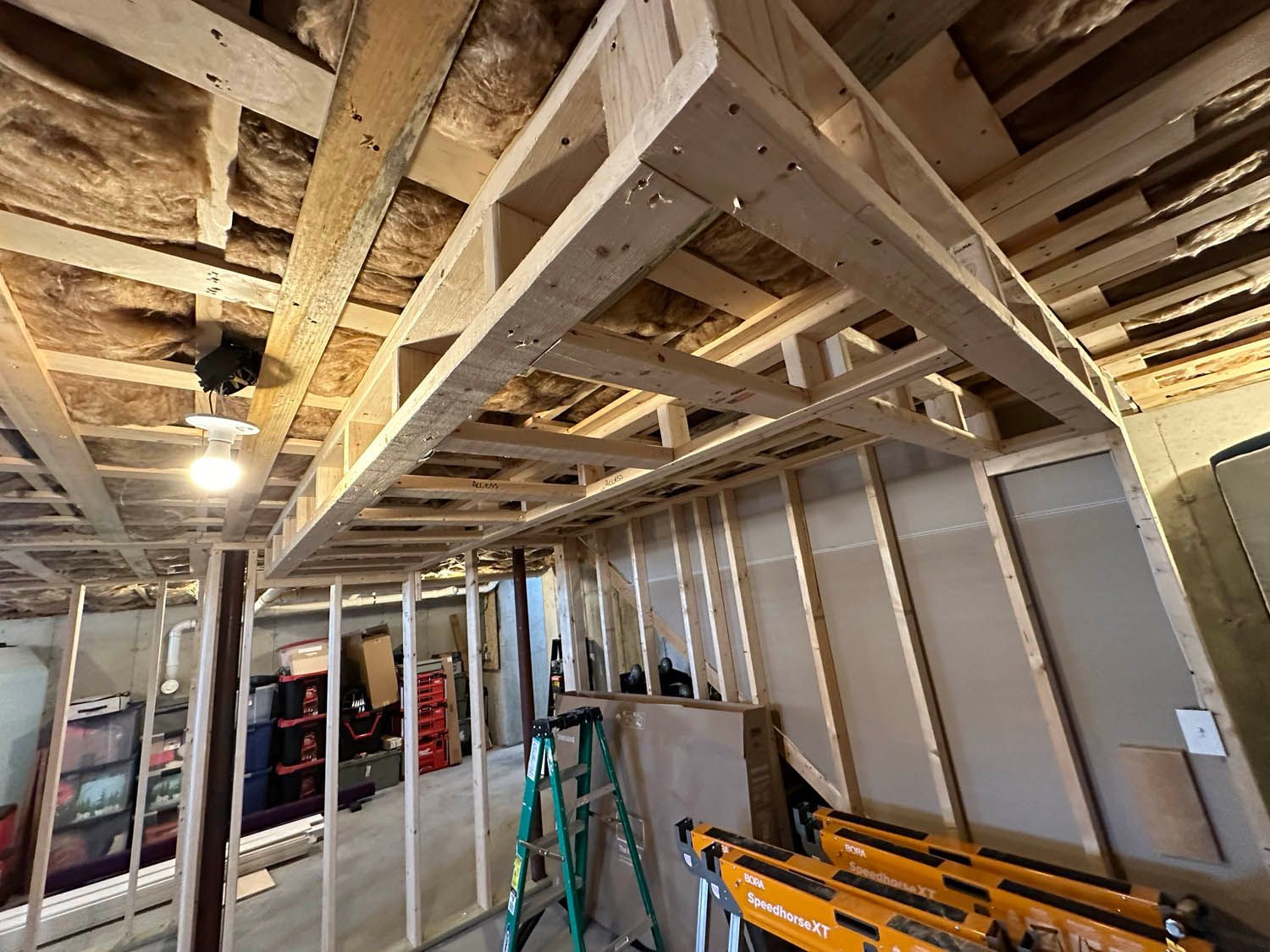 A ladder is sitting in the middle of a room under construction.
