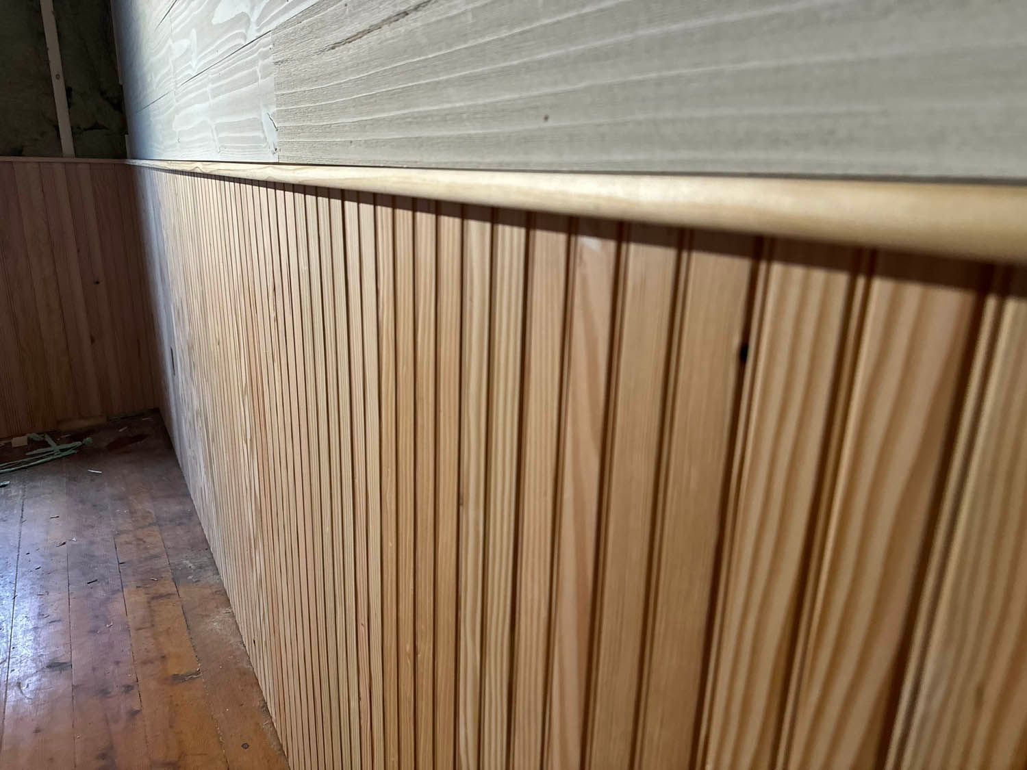 A wooden wall with a wooden floor in a room.