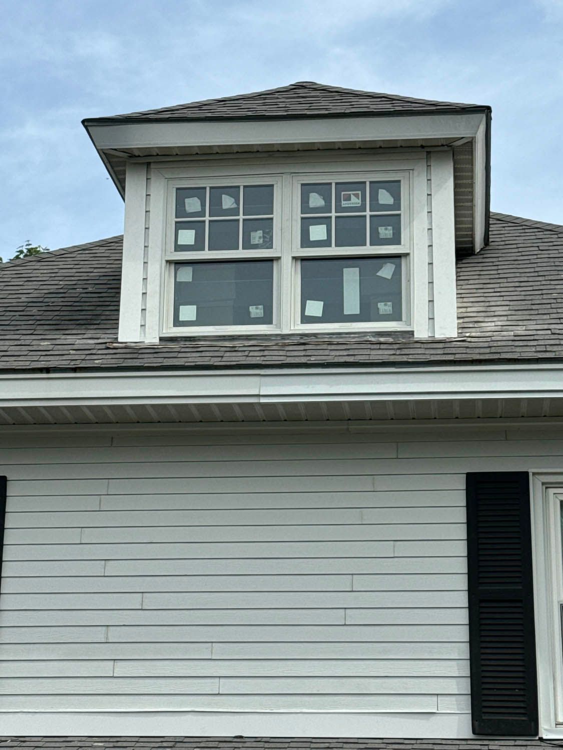 A white house with a window on the roof