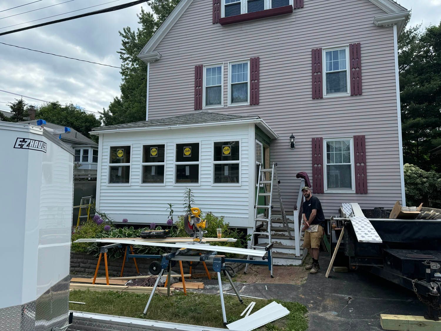 A man is standing in front of a house that is being remodeled.