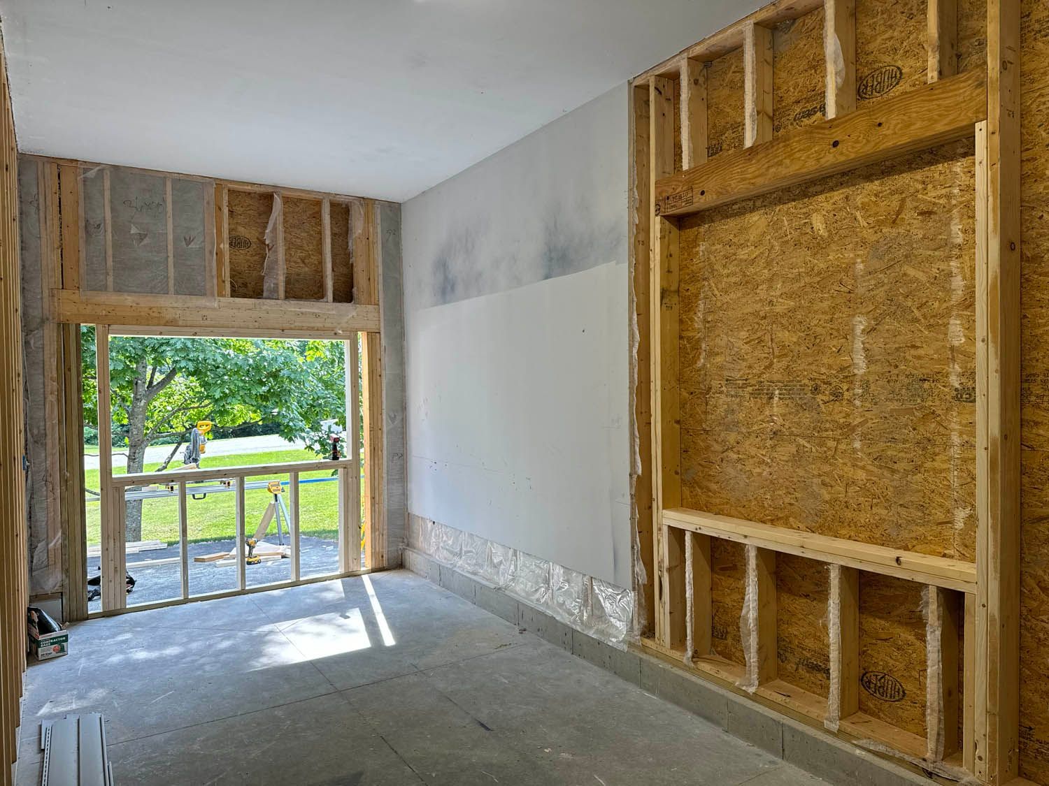 A room in a house under construction with a large window.