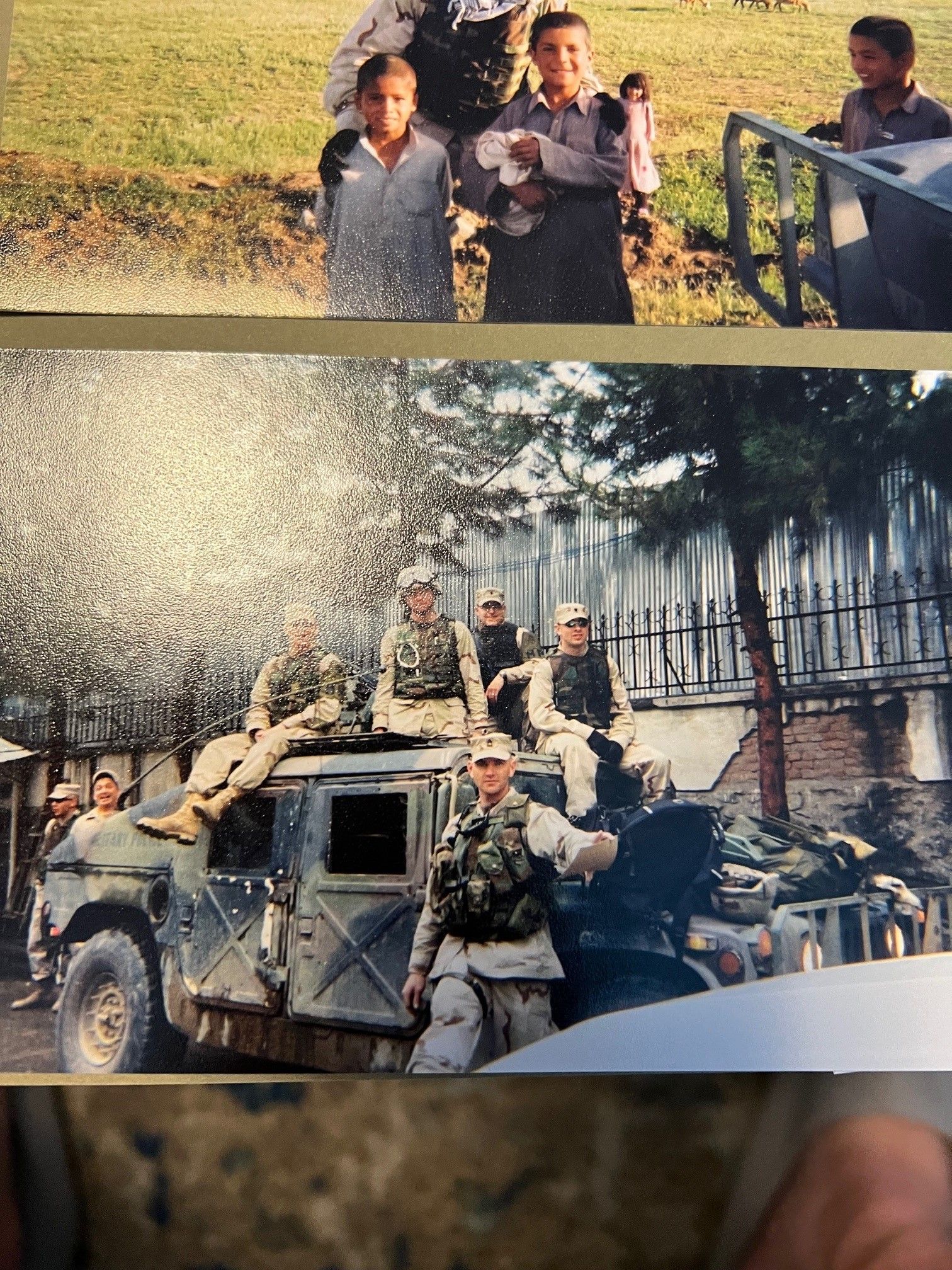 A group of soldiers are standing on top of a military vehicle