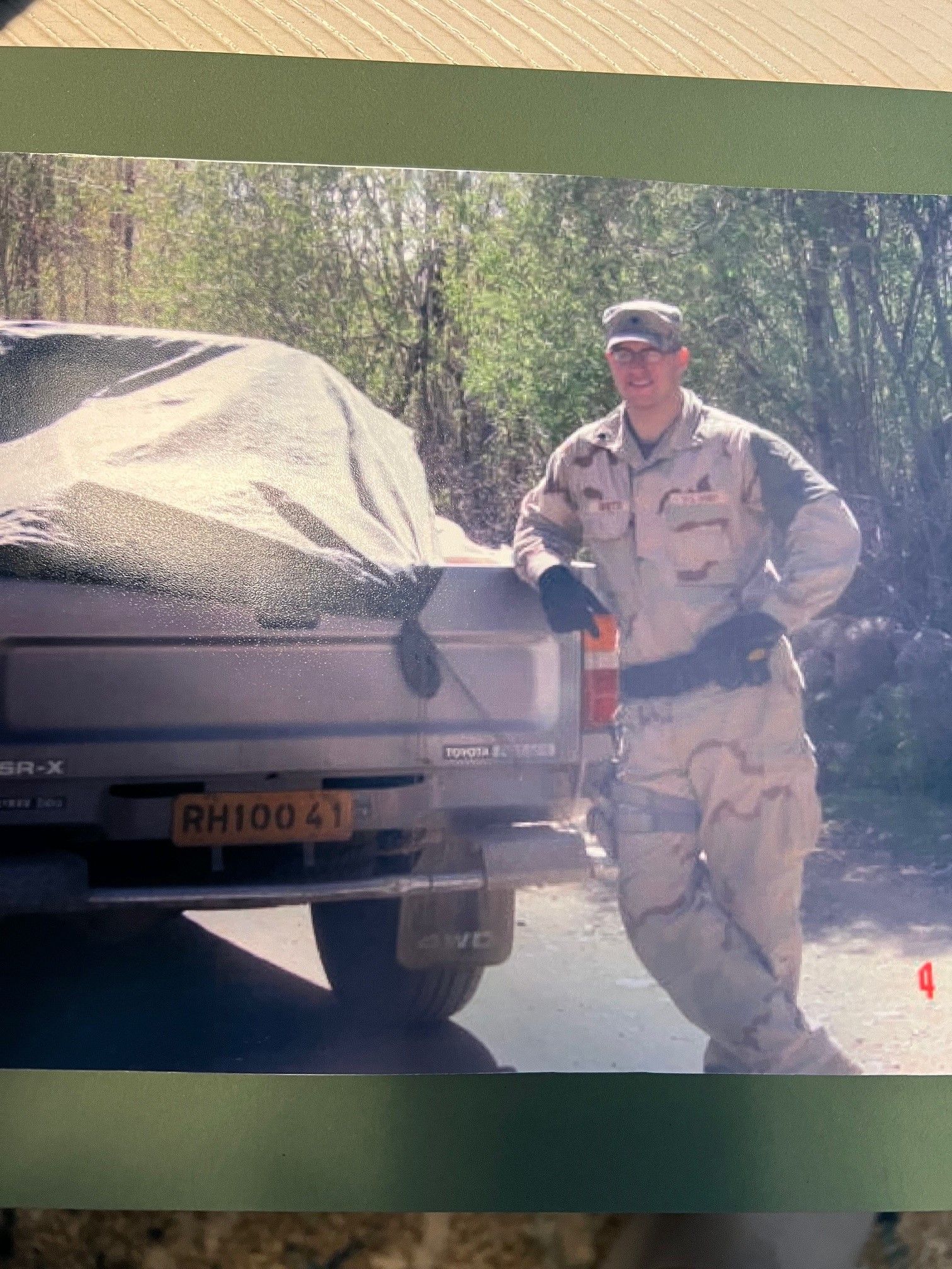 A man standing next to a truck with a license plate that says rh100 41