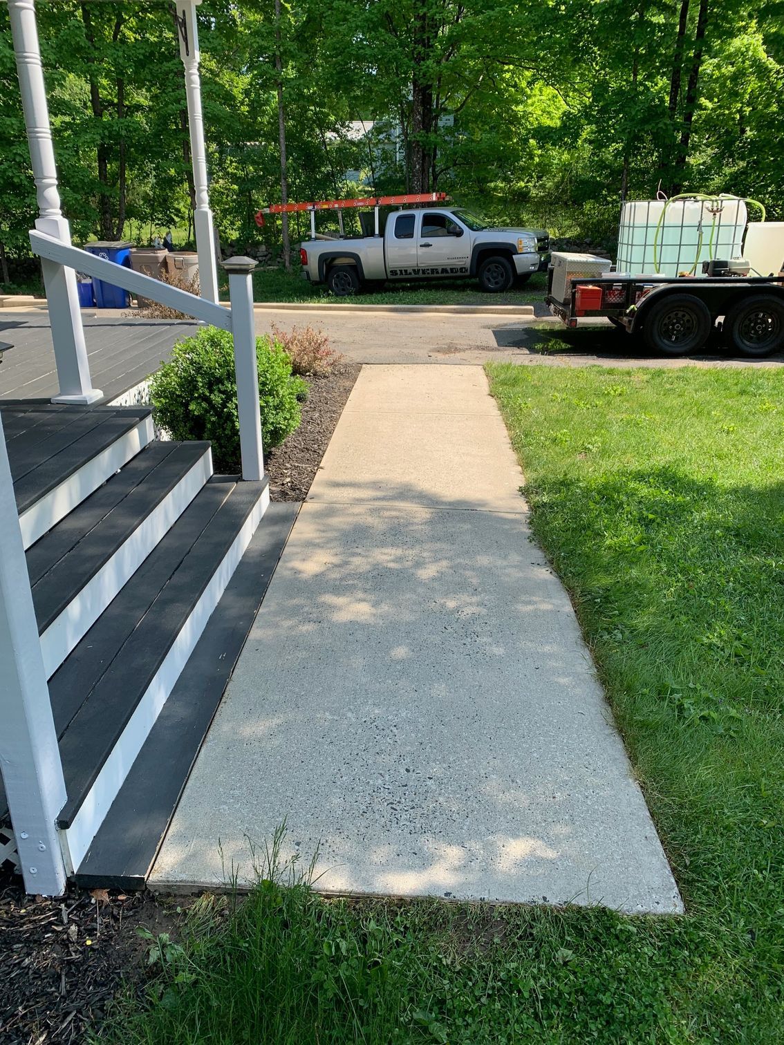 A white truck is parked on the side of the road next to a sidewalk.