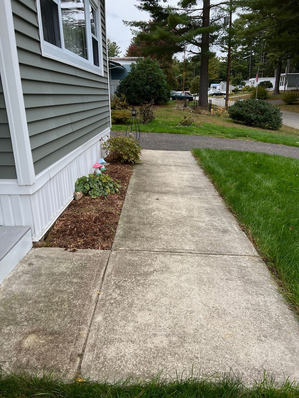 A sidewalk leading to a house with a lot of grass.