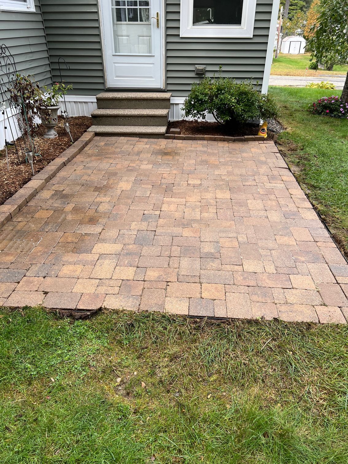 A brick walkway leading to the front door of a house.