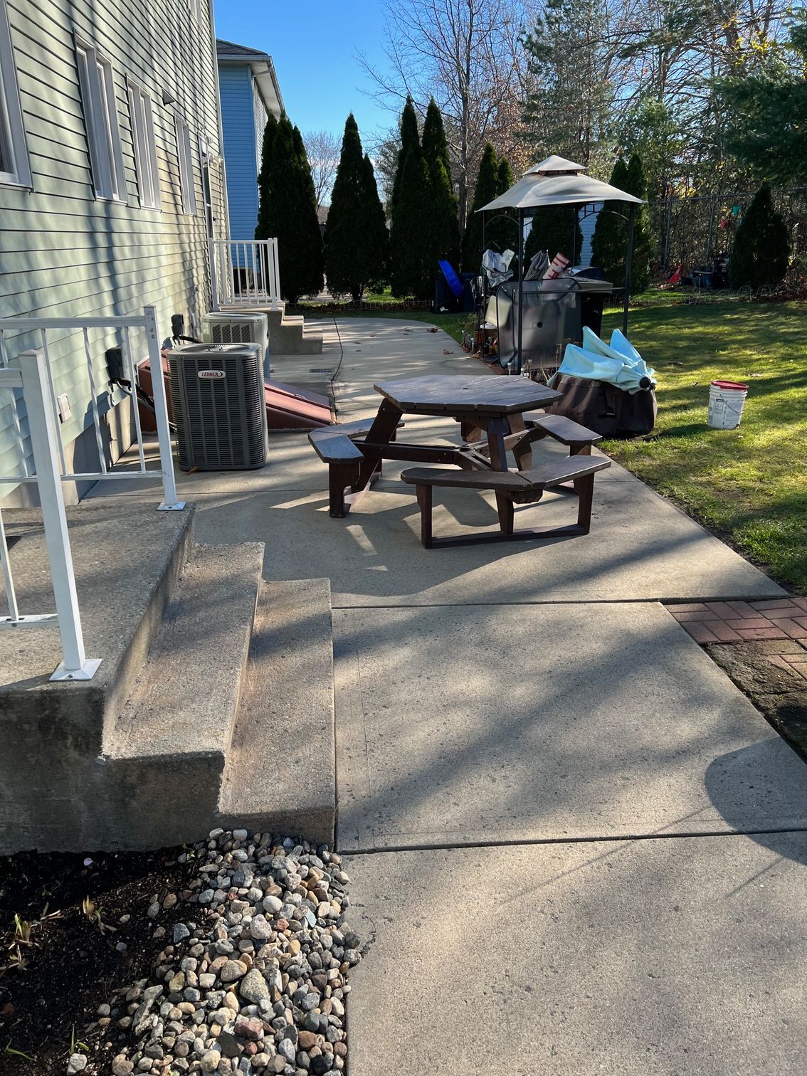 A concrete walkway with a picnic table and chairs on it.